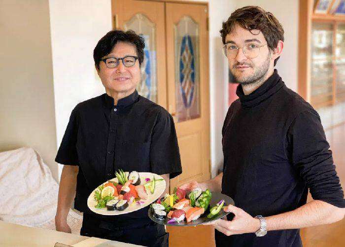 Two smiling guests at a sushi and wagyu cooking class.